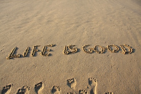 12002584 - life is good message written on a sandy beach.
