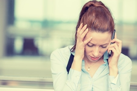 37960928 - portrait unhappy young woman talking on mobile phone looking down. human face expression, emotion, bad news reaction