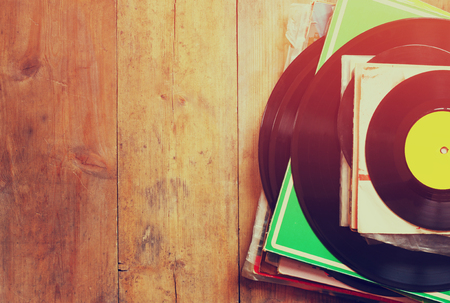 48054167 - records stack with record on top over wooden table. vintage filtered