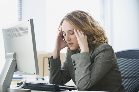 7467050 - a young businesswoman is looking stressed as she works at her computer. horizontal shot.